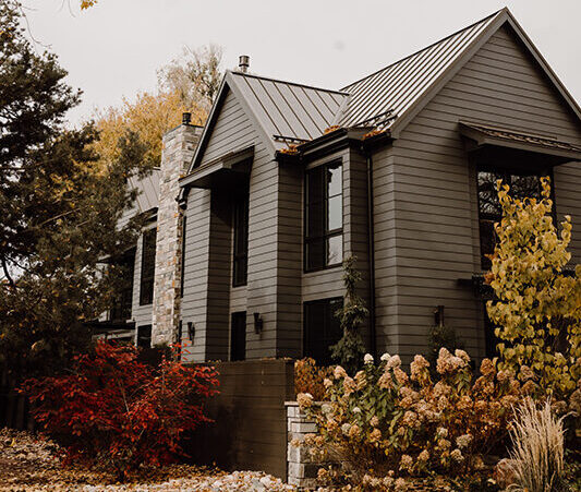 A modern home in Old Town Fort Collins, characterized by its tall, dark, and dramatic exterior. The sleek design features clean lines and a striking, elegant facade that stands out against the historic neighborhood. The dark materials and minimalist architecture give the home a sophisticated and bold presence."