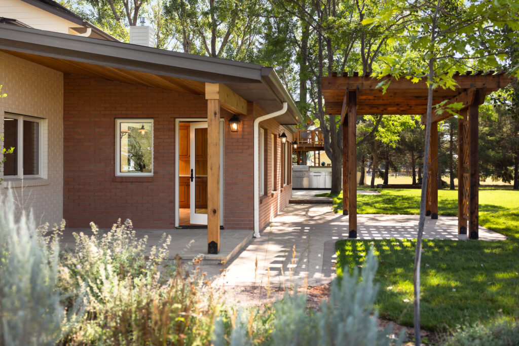 The exterior was equally transformed, featuring a brick addition that integrates seamlessly with the original structure. An expanded stone patio and rebuilt pergola offer the perfect setting for outdoor living, blending beautifully with the surrounding landscape. This remodel highlights the perfect marriage of rustic charm and modern design, creating a comfortable, elegant space for the homeowners to enjoy.